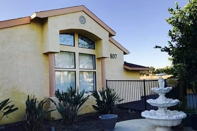 Exterior view of the Sunny Place building with a fountain