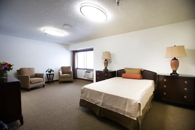 A bright and spacious resident room with beds and seating