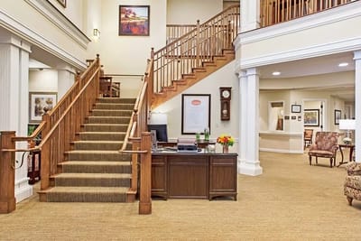 Warm and welcoming lobby with a staircase and reception desk