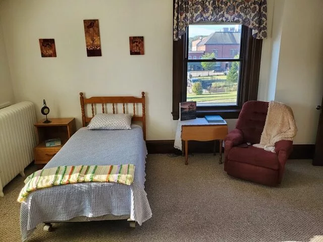Private resident room with a bed and chair
