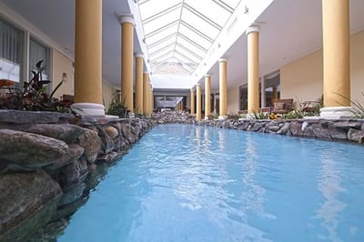 Indoor pool area with decorative columns and bright lighting