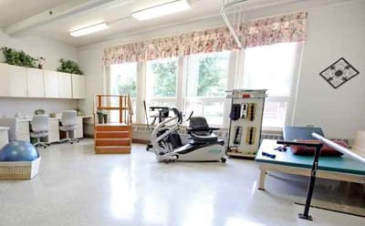 Rehabilitation gym area with equipment and natural light