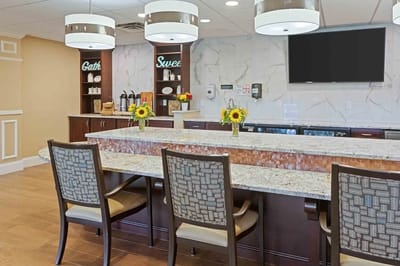 Bright common area with granite counter and flowers