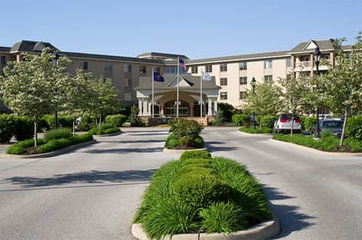 Front entrance of Westside Village Nursing Center surrounded by greenery