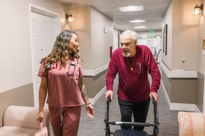Staff assisting a resident in a hallway