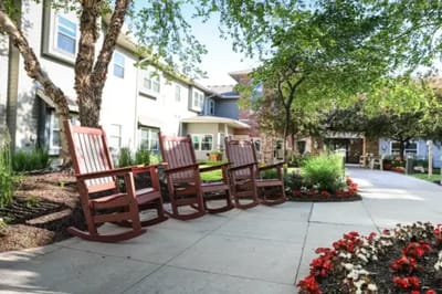 Outdoor seating area with rocking chairs and flowers
