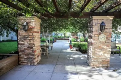 Outdoor walking path with stone columns and greenery