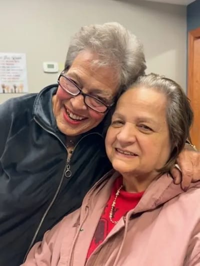 Two smiling residents posing together indoors
