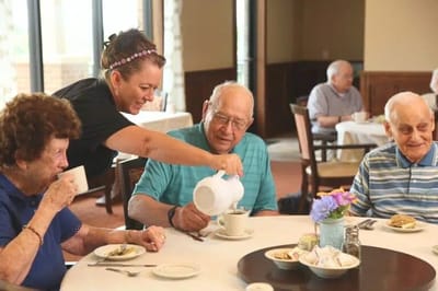 Staff serving coffee to residents in dining area