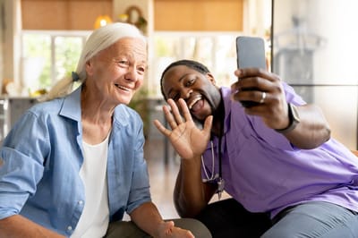 A resident and staff member taking a selfie together