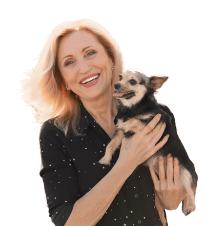 A smiling woman holding a small dog