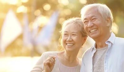 Two seniors smiling happily outdoors