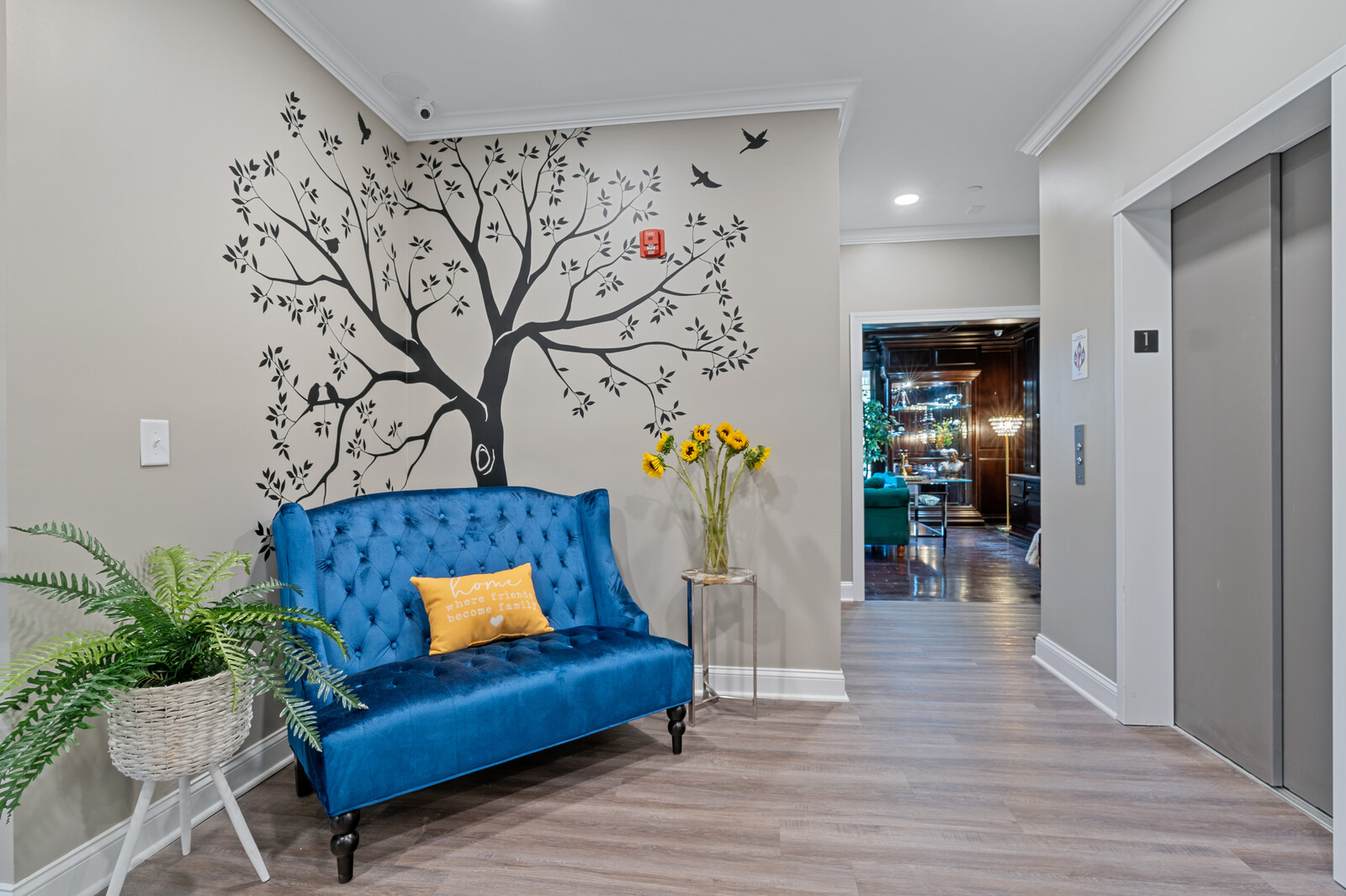 Bright lobby area with tree mural and blue sofa