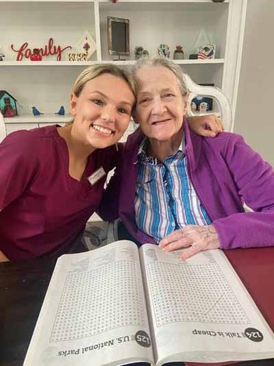 A caregiver and resident smiling together