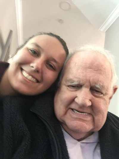 Resident and staff member smiling together