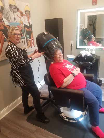 Hair salon scene with resident receiving treatment
