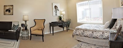 A cozy resident room with a bed and seating area