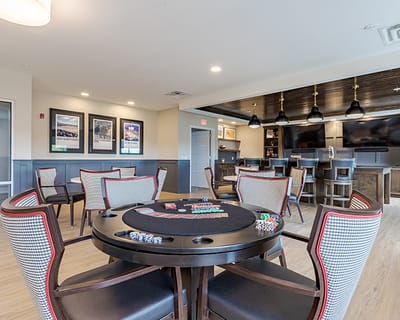 Interior of a common area with a poker table and lounge chairs