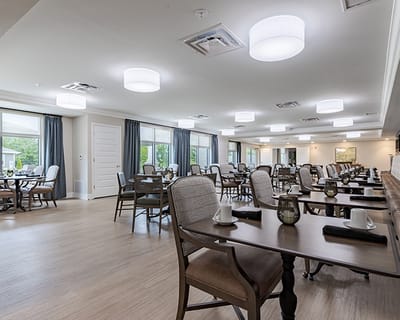 Clean dining room with tables set for residents