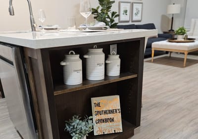 Modern kitchen setup with decorative jars and a cookbook.