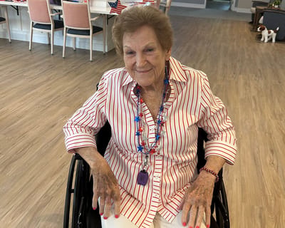 Resident in a wheelchair smiling in a social space