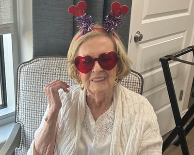 Resident enjoying a fun celebration with heart-themed accessories