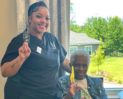 Resident and staff member holding foam fingers