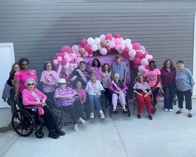 Residents in pink attire at a celebration outdoors