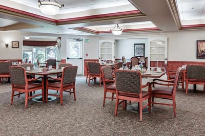 Dining area with tables and chairs set for residents