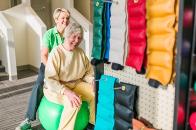 Resident enjoying exercise with staff support