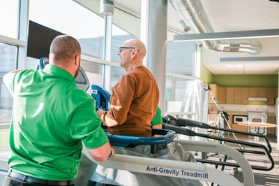 Therapist assisting a resident on an anti-gravity treadmill
