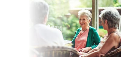 Three seniors enjoying conversation in an outdoor setting