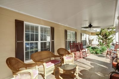 Outdoor porch with wicker chairs and a table