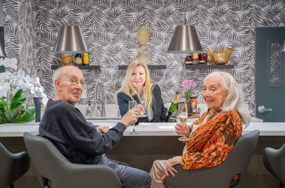 Residents enjoying drinks at the bar with staff