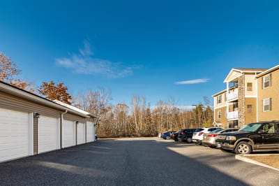 Parking area with building and trees in the background