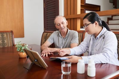 A healthcare professional and a resident discussing medication.