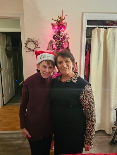 Two women posing in a festive interior space