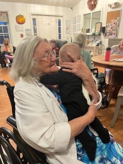Resident joyfully embracing a child in a common area