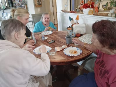 Residents and staff enjoying an activity around a table