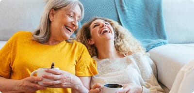 Two women enjoying coffee and laughing together