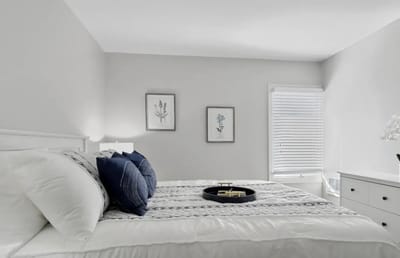 A cozy bedroom with neutral decor and a neatly made bed