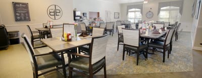 Dining area with tables and chairs set for meals