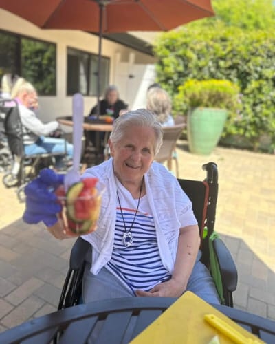 Resident enjoying a fruit dessert in the garden