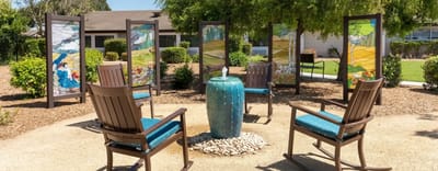 Outdoor seating area with artistic panels and a fountain