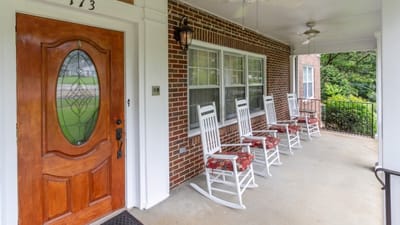 Rocking chairs on a porch outside a senior care facility