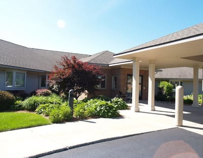 Welcoming entrance with landscaping at assisted living facility