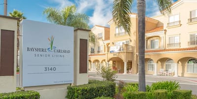 Exterior view of Bayshire Carlsbad with facility sign