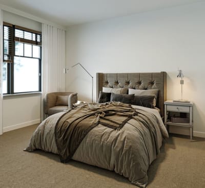 Cozy private resident room with a bed and armchair