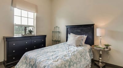 Bright private resident room with bed and lamp
