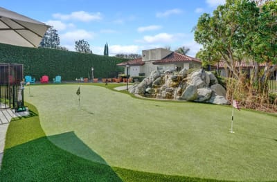 Outdoor putting green with landscaping and seating